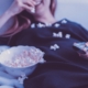 Woman with bowl of popcorn and TV remote control